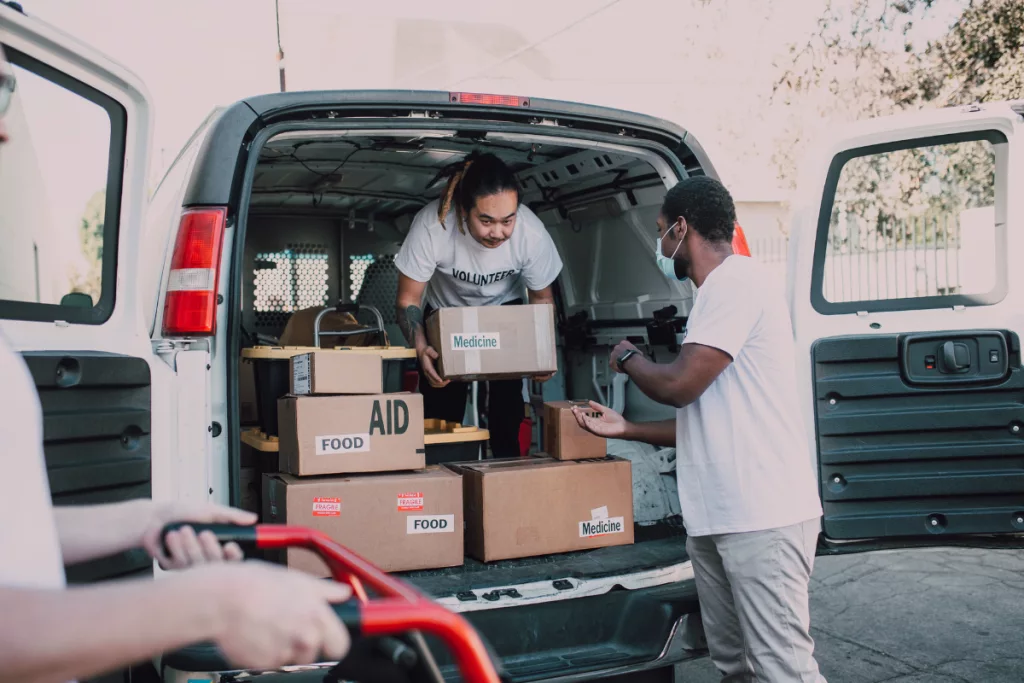 Two people loading boxes into a van.