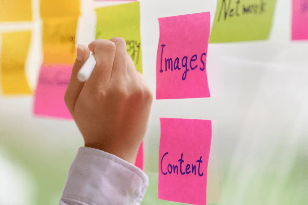 A person writing on a sticky note with the words content and images.