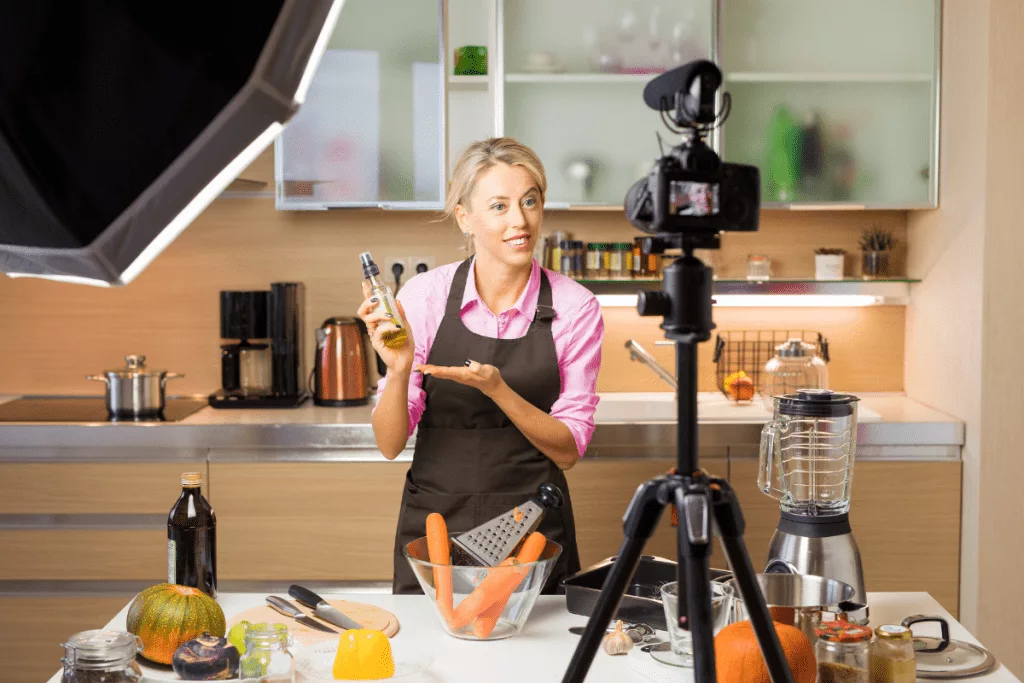 A woman in an apron holding a camera.