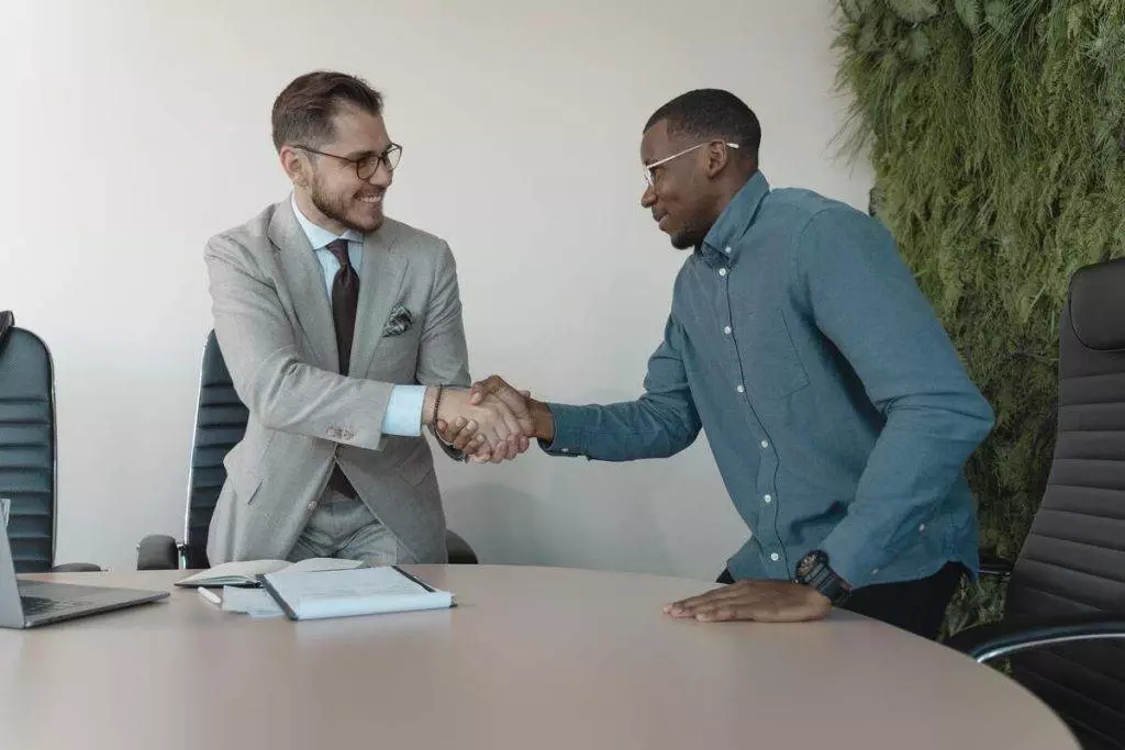 Two businessmen shaking hands in an office.