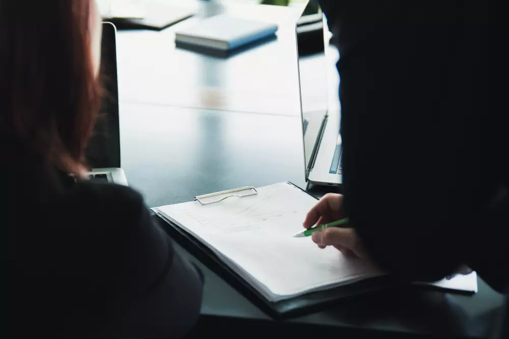 Business professionals reviewing documents and collaborating in a modern office setting.